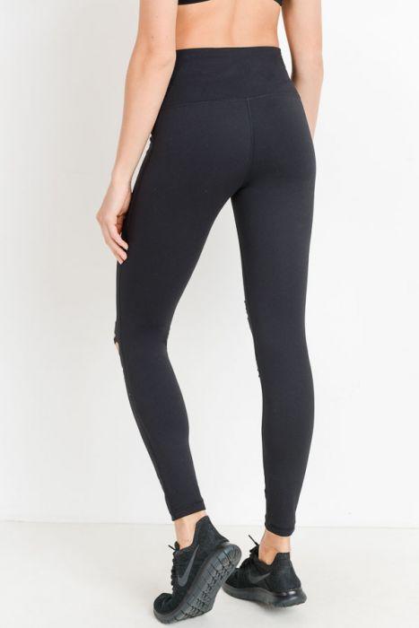 A person is wearing a black crop top and High Waist Laser Cut Ripped Knee Leggings boasting moisture-wicking properties, paired with black shoes.