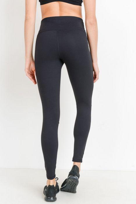 A person is wearing a black crop top and High Waist Laser Cut Ripped Knee Leggings boasting moisture-wicking properties, paired with black shoes.