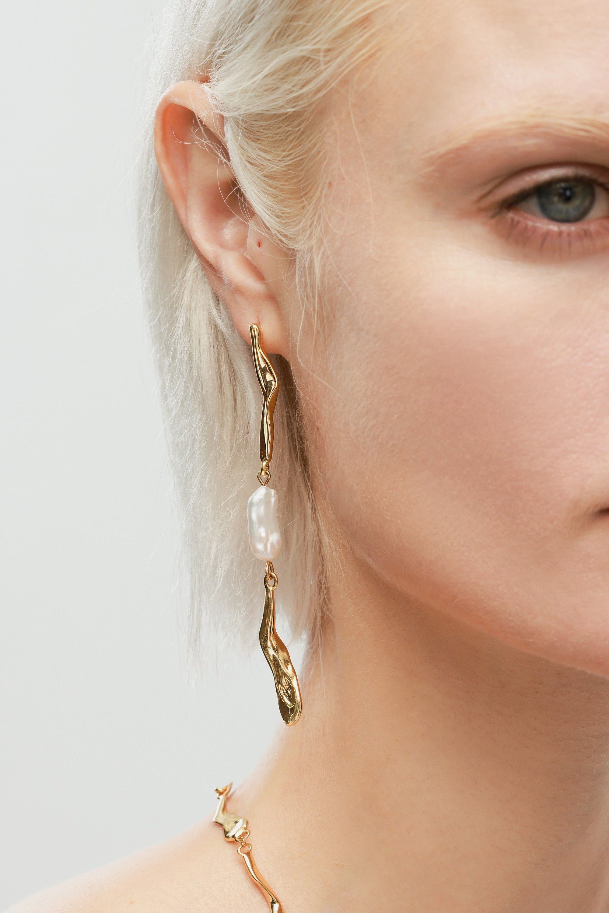 A pair of Gold Asymmetrical Molten Baroque Pearl Earrings.