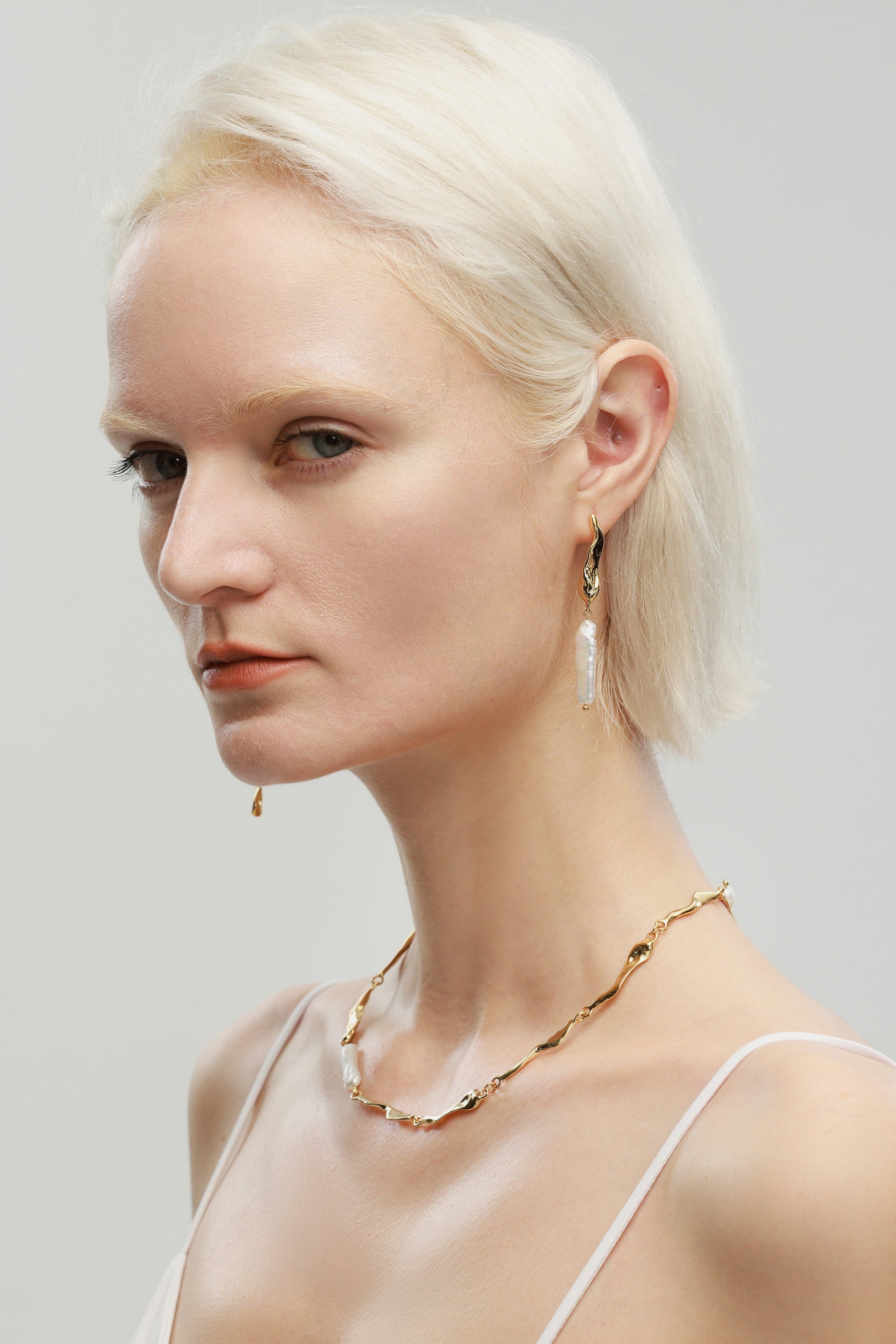 A pair of Gold Asymmetrical Molten Baroque Pearl Earrings.