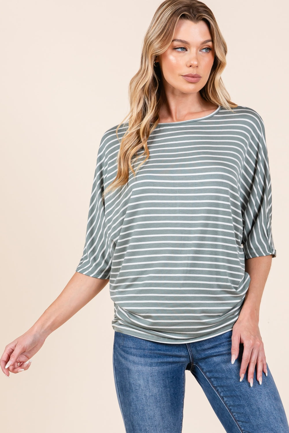 A person with long, wavy hair wearing the BOMBOM Striped Boat Neck Dolman Sleeve Top and blue jeans poses against a plain background.