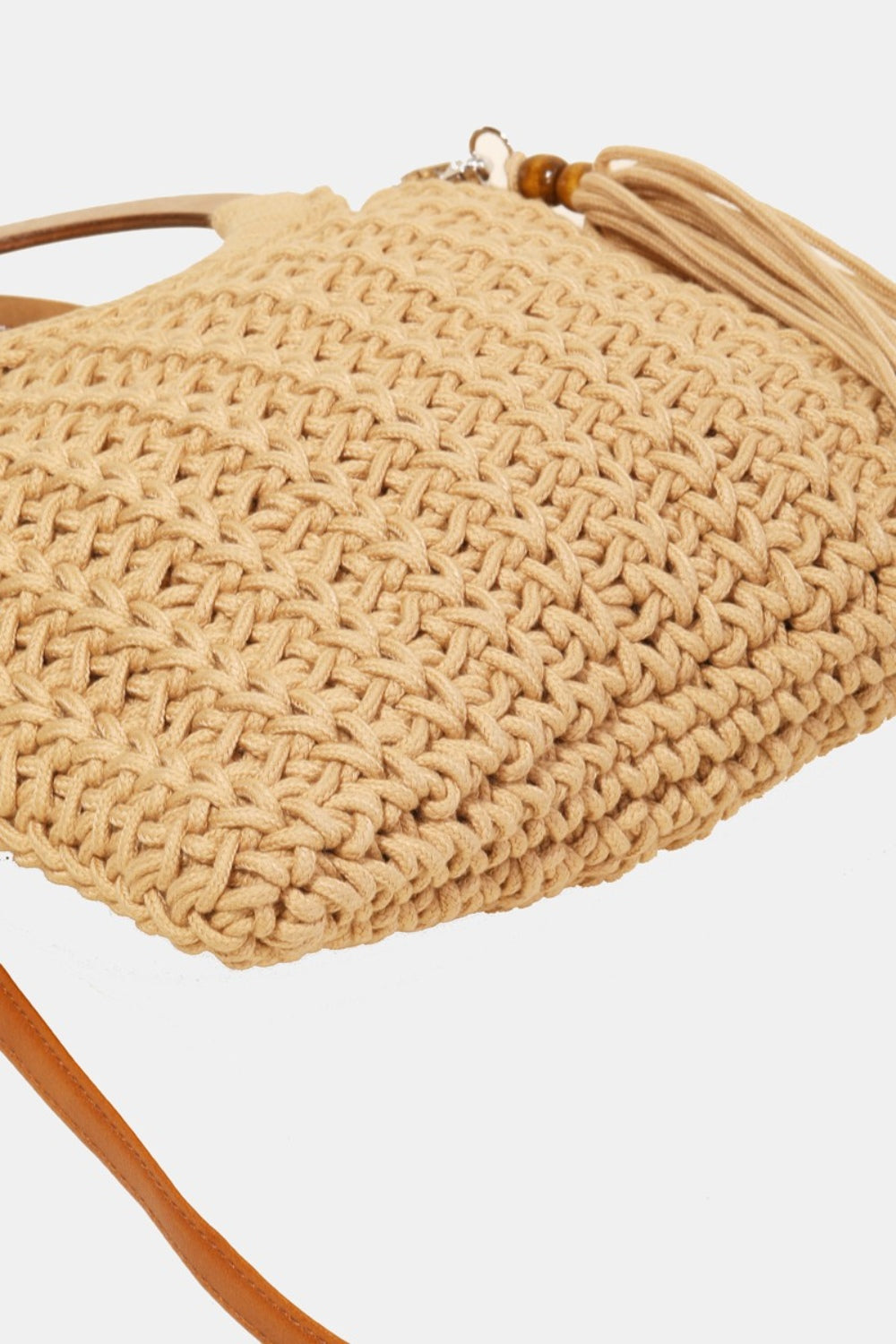 The Fame Crochet Knit Convertible Tote Bag includes a cream-colored design with round wooden handles and a matching tassel accent.