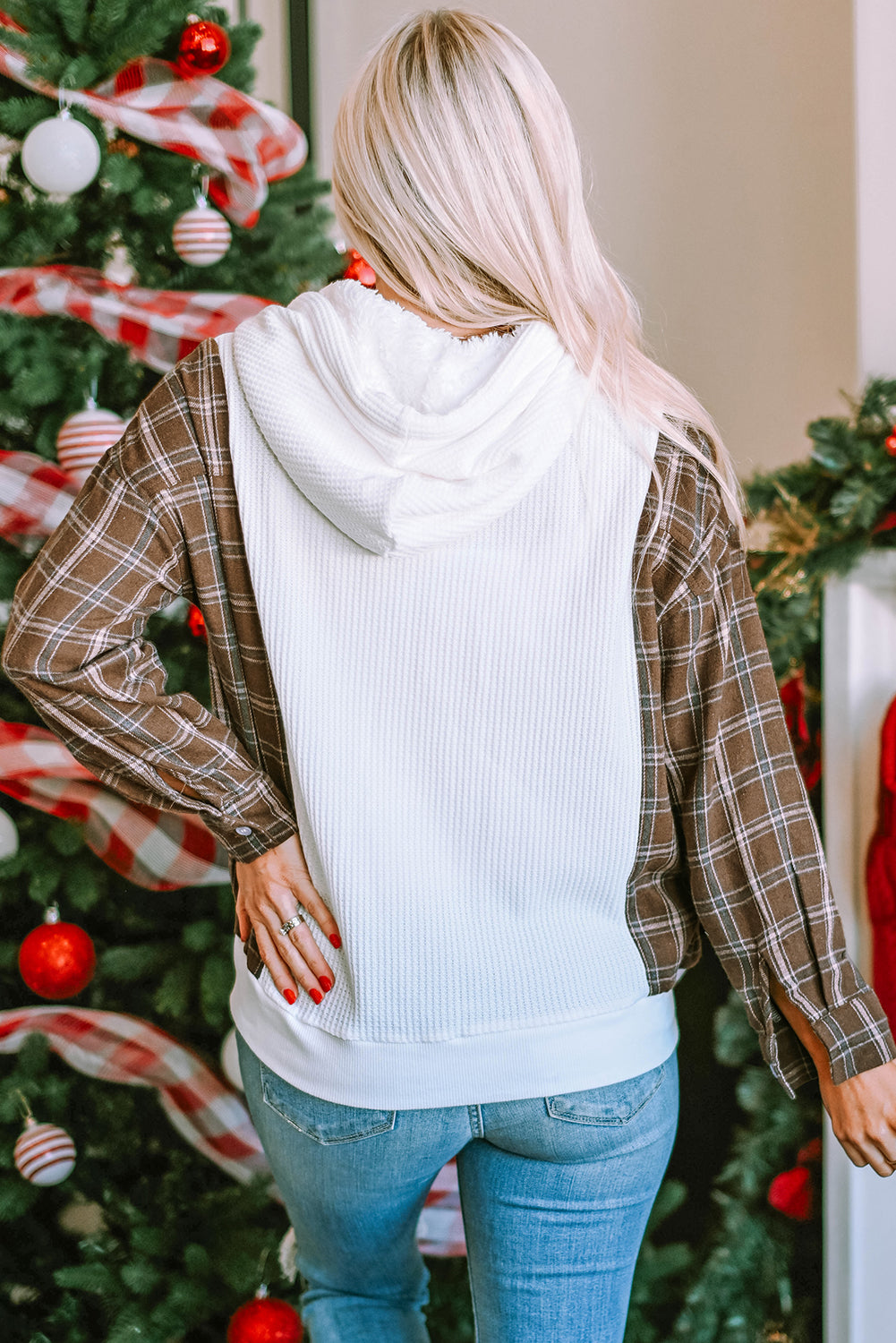 A person with blonde hair, wearing a White Waffle Patch Plaid Sleeve Kangaroo Pocket Hoodie, stands facing away in front of a decorated Christmas tree.