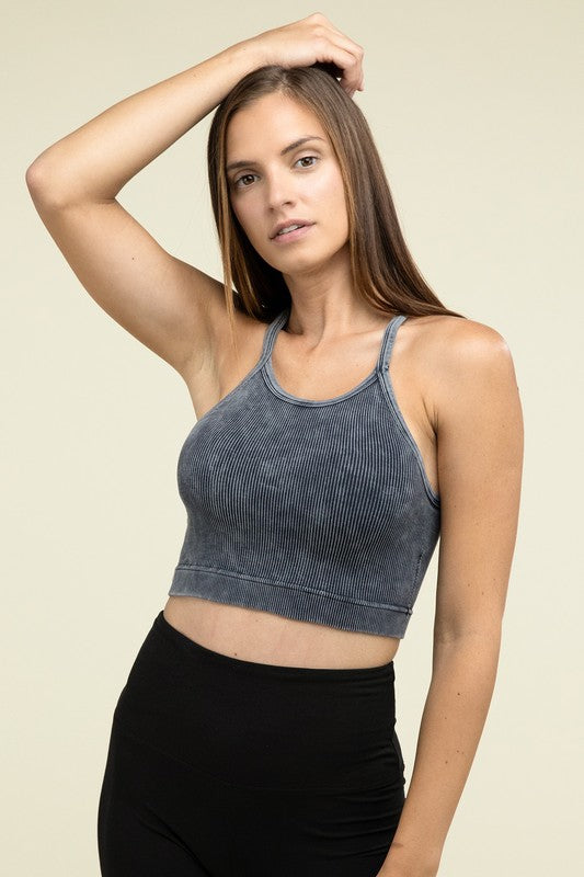 A person poses in a Washed Ribbed Seamless Cropped Cami Top with removable bra pads and black leggings against a neutral background.