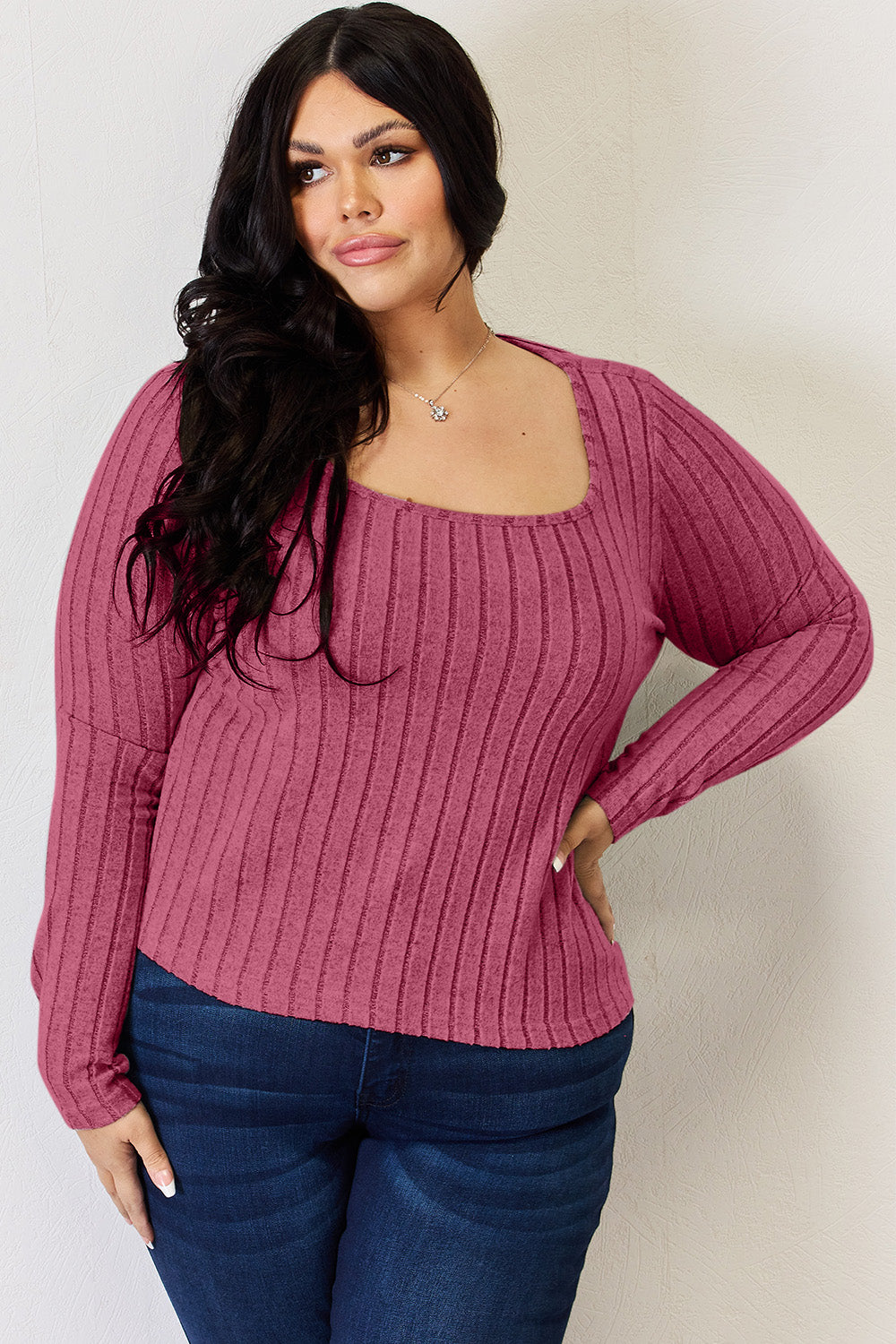 A person is standing and smiling, wearing the Basic Bae Full Size Ribbed Long Sleeve T-Shirt in light brown along with jeans. The basic style is perfect for any casual outing.