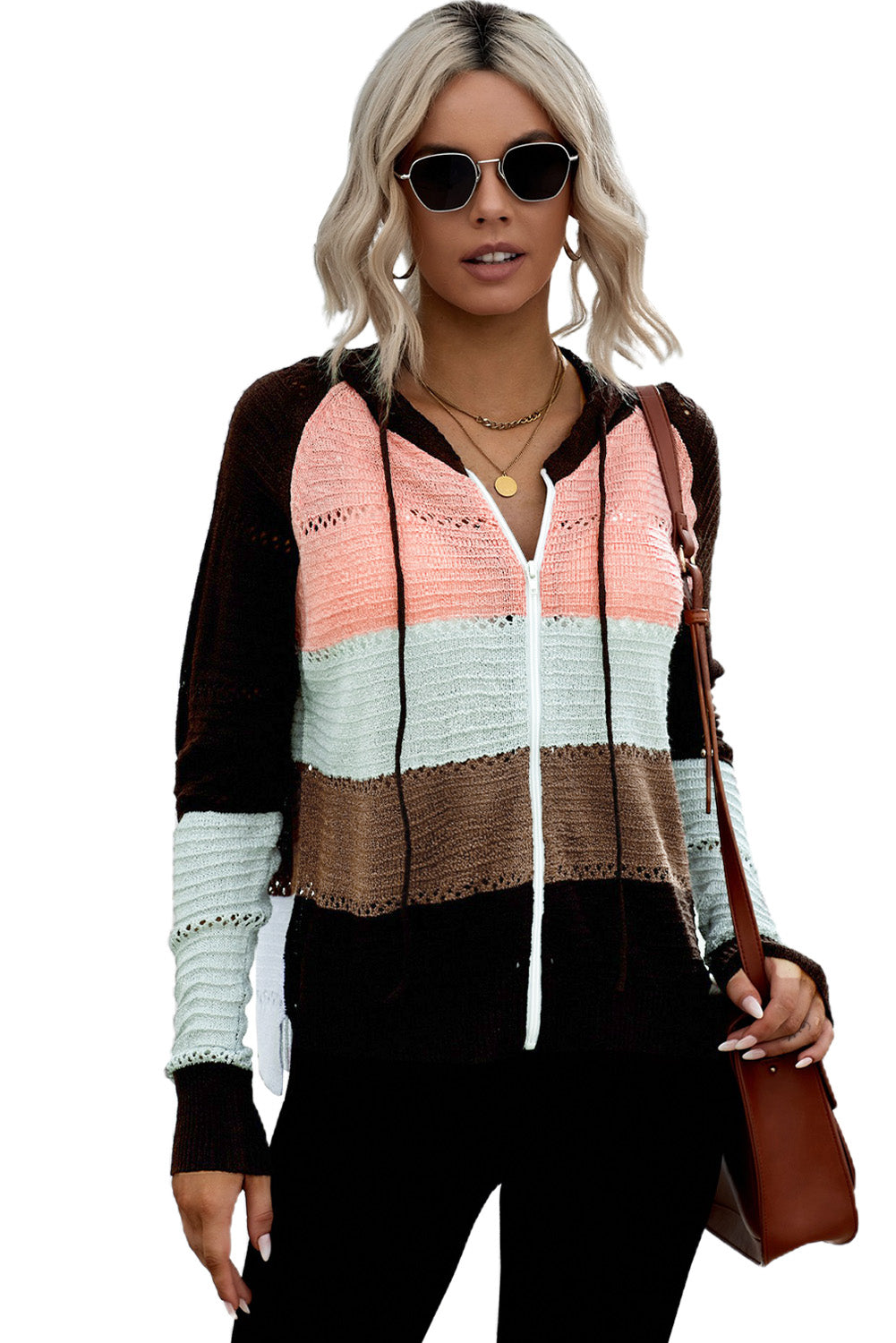 A person wearing the Brown Zipped Front Colorblock Hollow-out Knit Hoodie, featuring a multi-colored striped design with alternating bands of brown, pink, white, and gray. Seen from the back, the sweater showcases the hood and finely knitted texture. The person has long wavy hair—a perfect look for a bonfire on the beach.