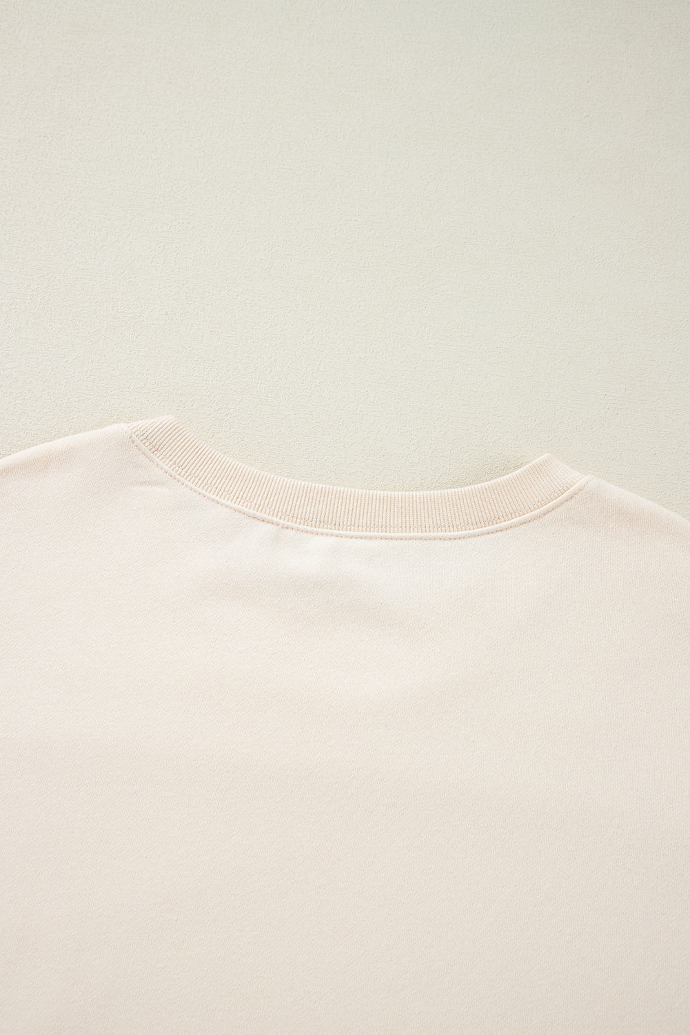 A person with long hair is wearing an Apricot Corduroy Patchwork Drop Shoulder Long Sleeve Sweatshirt, standing with their back to the camera against a light blue corrugated metal wall.