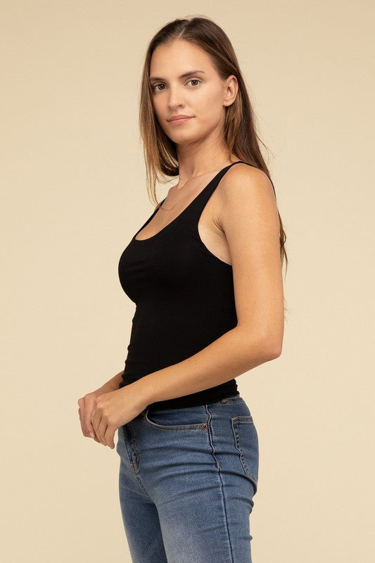 Dressed in a Double Layer Round Neck Tank Top and jeans, the person exudes stylish comfort while standing against a beige background.