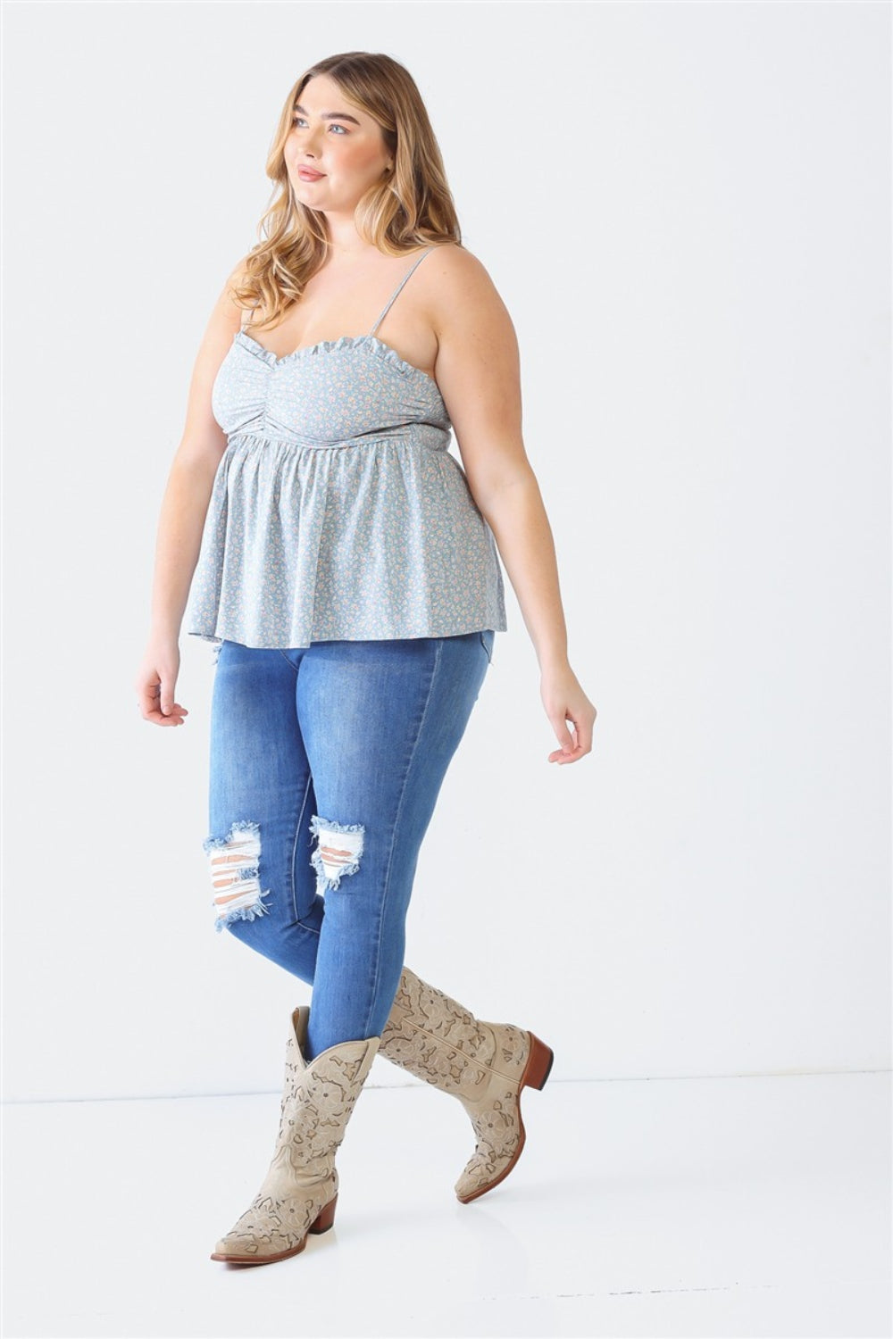 A woman stands facing the camera wearing a Zenobia Plus Size Frill Smocked Floral Sweetheart Neck Cami with dark jeans, against a plain background.