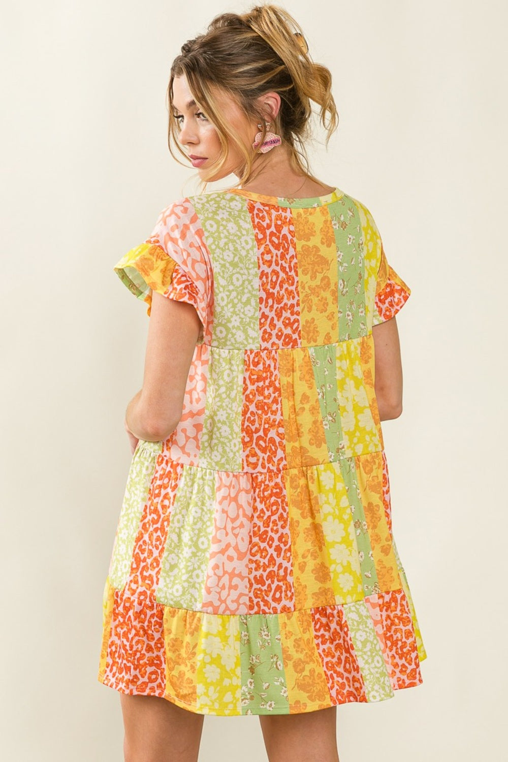 The BiBi Leopard Short Sleeve Tiered Dress captivates effortlessly with its vibrant, flowy silhouette and layered design.