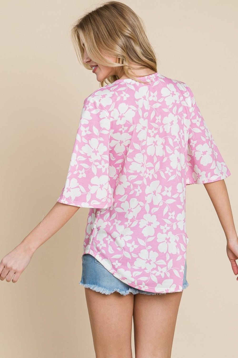 A woman wearing the BOMBOM Floral Decorative Button V-Neck Top in pink.