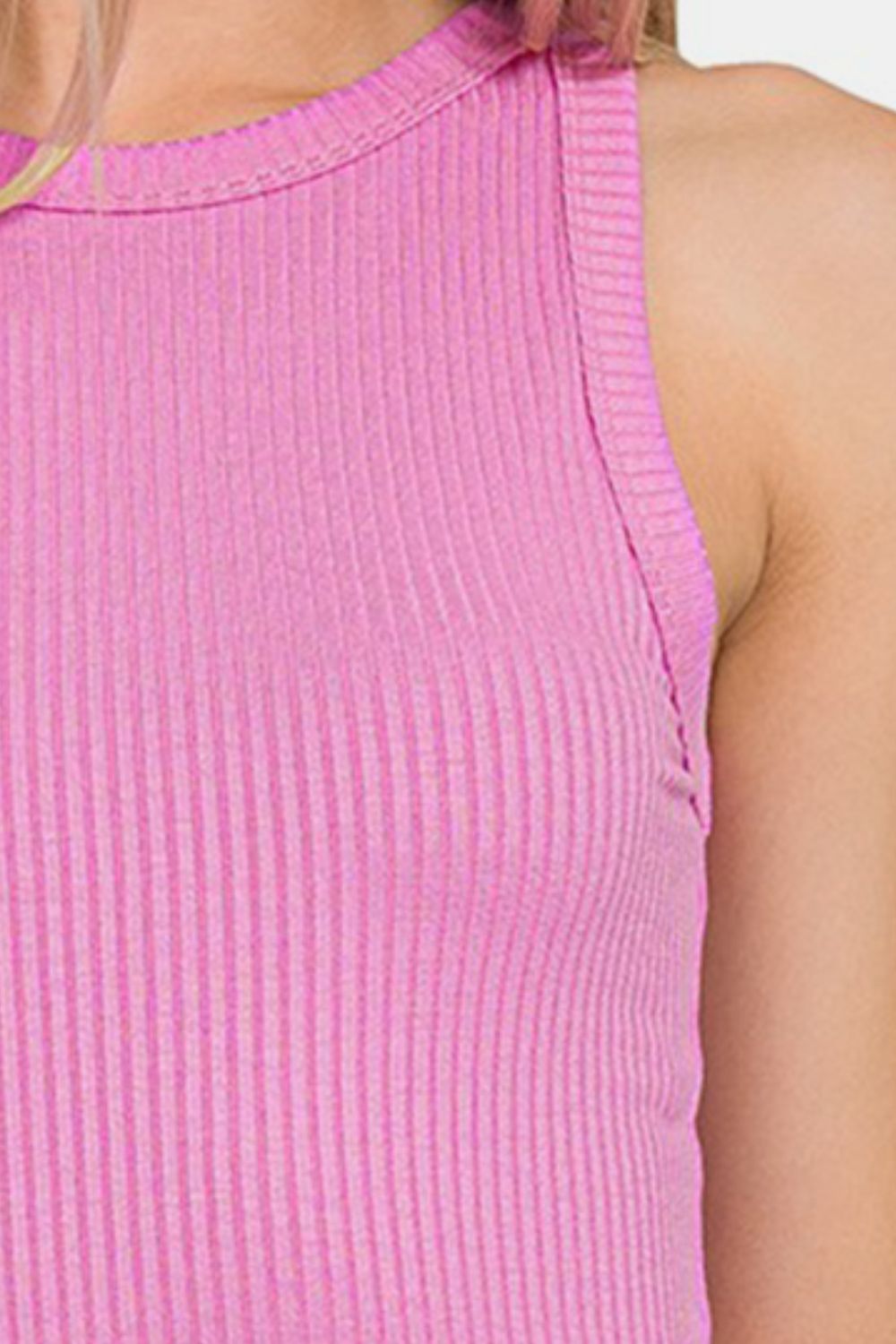 A woman wearing a Zenana Ribbed Crew Neck Tank in pink stands against a plain white background. She has long blonde hair and a neutral expression, showcasing this versatile wardrobe piece with understated elegance.