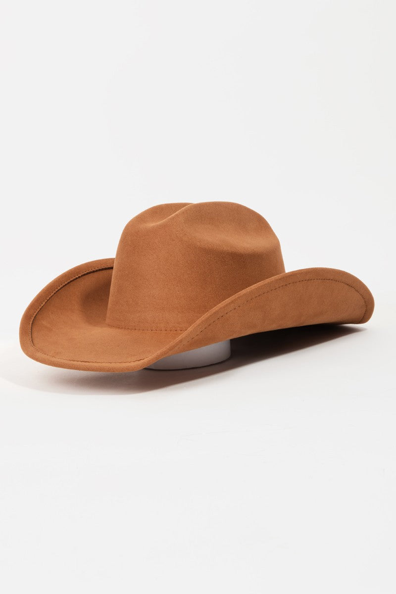 The Fame Solid Wide Brim Hat, showcasing a classic western style with its wide brim and creased crown, sits elegantly on a white surface.