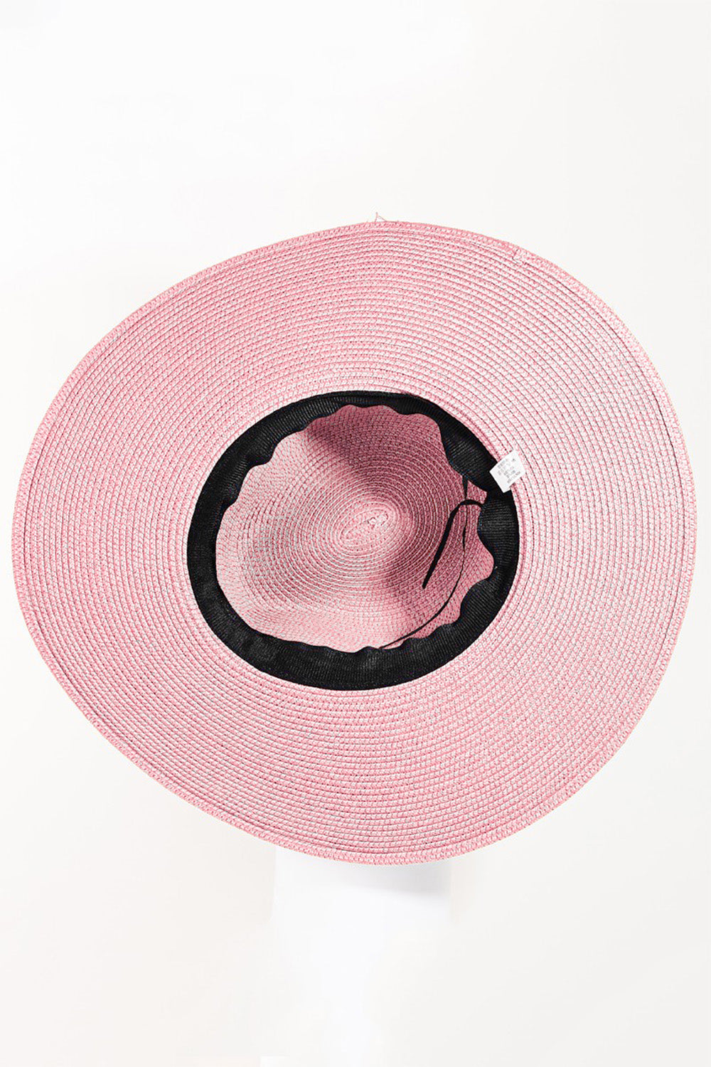 The Fame Straw Braided Rope Strap Fedora Hat exudes bohemian charm with its wide-brimmed design, pink straw material, braided rope trim, and tassel details, all beautifully displayed on a neutral background.