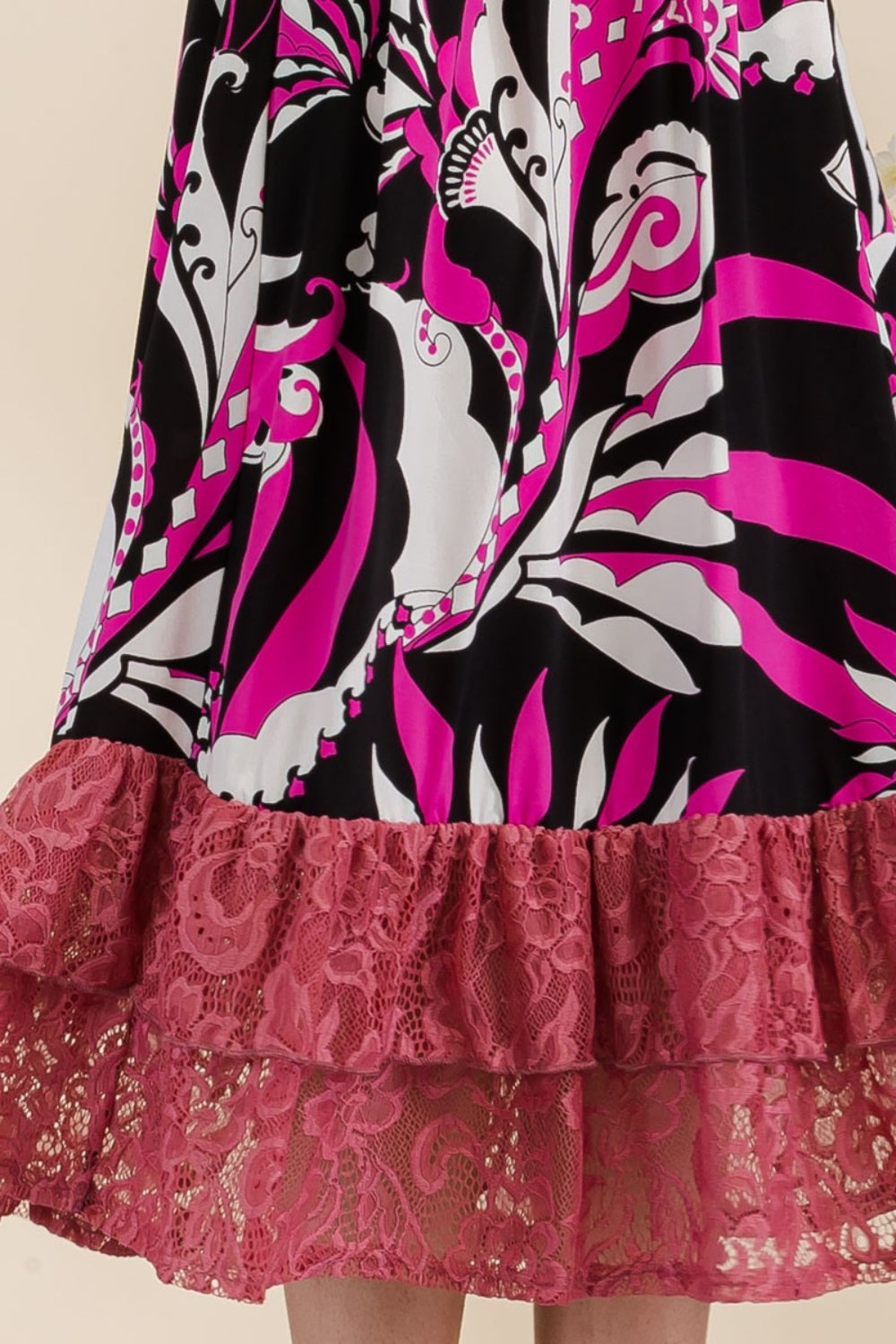 A woman wearing the Celeste Full Size Paisley Print Lace Ruffled Midi Dress poses gracefully for the camera indoors, standing beside metal planters filled with flowers.