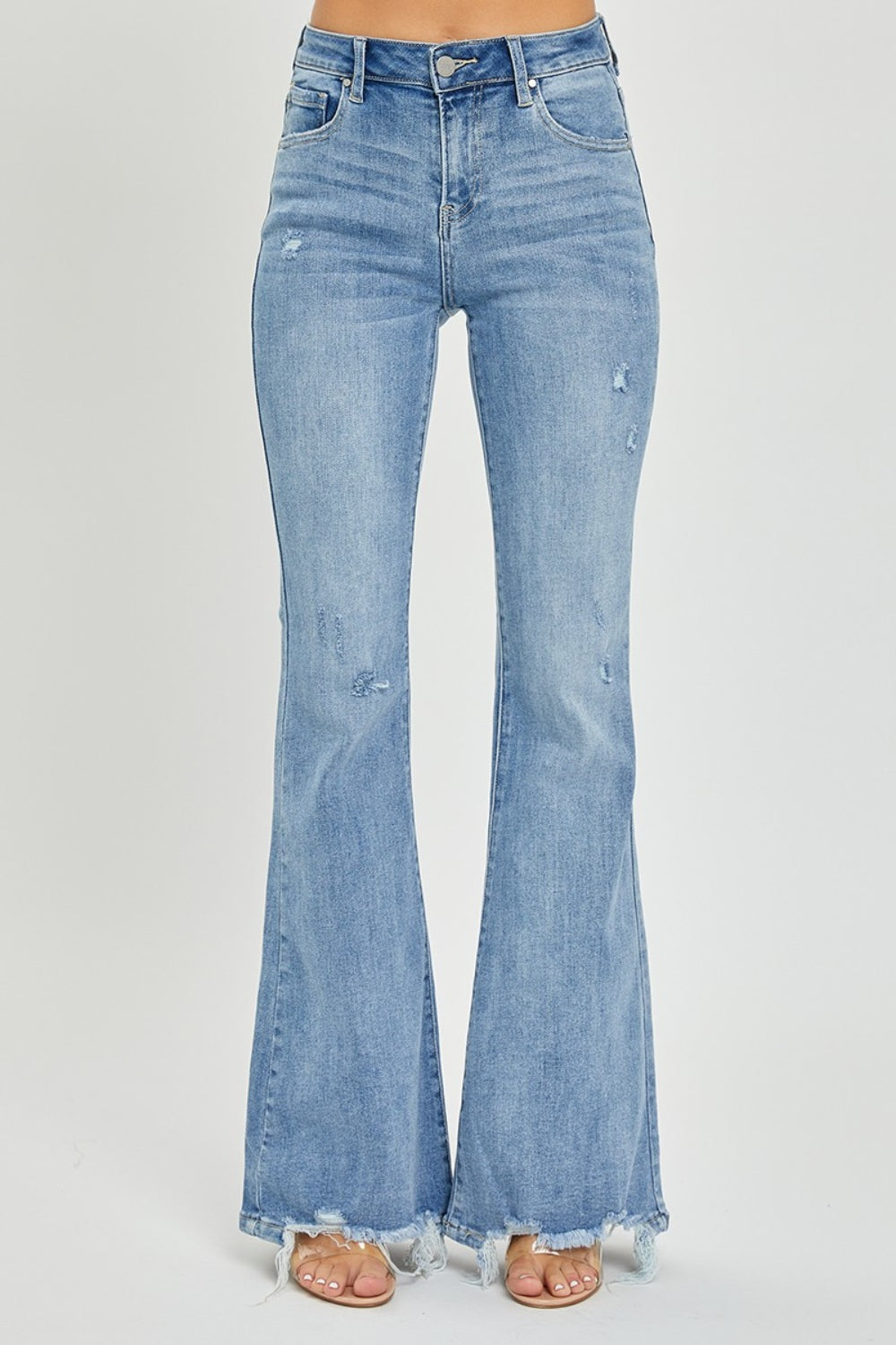 A person wearing the Risen Full Size High Rise Frayed Hem Flare Jeans in light blue with distressed details.