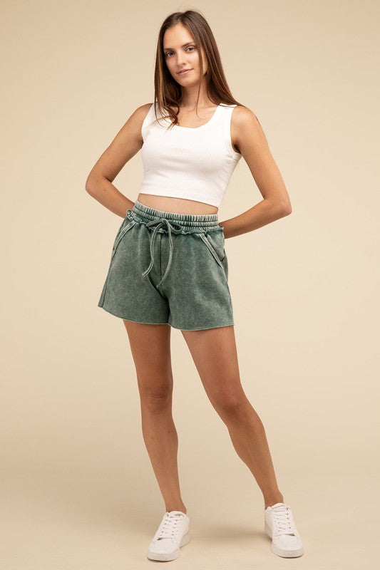 Person wearing a white crop top and green Acid Wash Fleece Drawstring Shorts with Pockets, standing against a plain background.