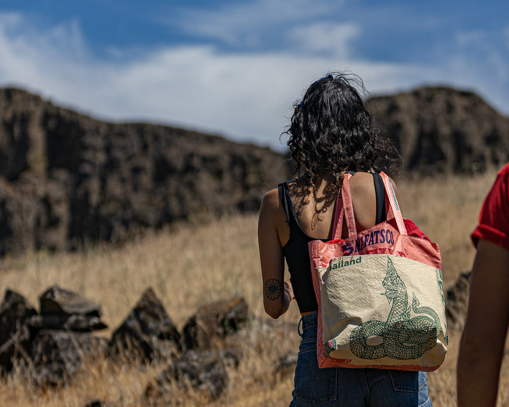 This lively Barrel Tote, made from recycled rice sacks, features whimsical frog graphics and genuine Vietnamese text, embodying a Portland-inspired design.