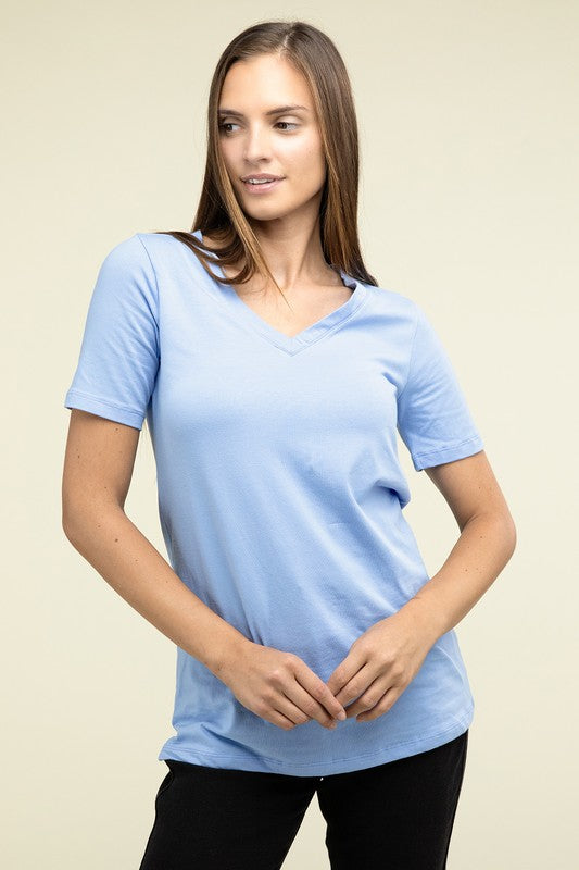 A person with long hair is standing and wearing a light blue Cotton V-Neck Short Sleeve T-Shirt and black pants.