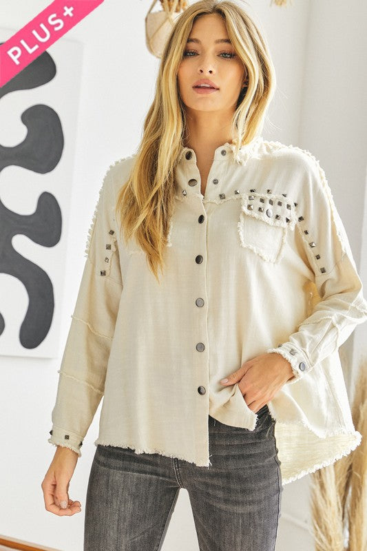 A person with dark hair wearing a Plus Distressed Hem Button Down Oversize Shirt and jeans stands against a light background, embodying casual comfort.