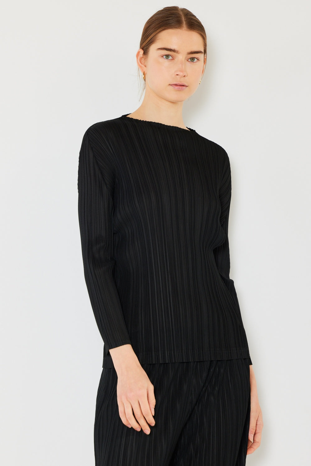 A person wearing the Marina West Swim Pleated Long Sleeve Boatneck Top with matching pants stands against a plain background.