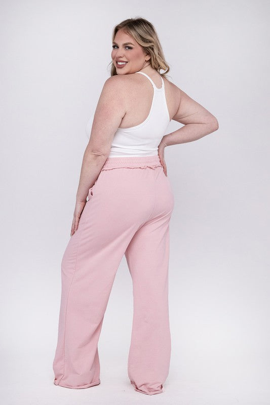 A person wearing the Plus F/Terry Drawstring Waist Raw Edge Hem Pants in pink, paired with white shoes, stands against a plain background.