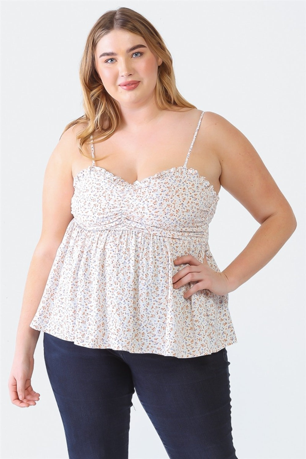 A woman stands facing the camera wearing a Zenobia Plus Size Frill Smocked Floral Sweetheart Neck Cami with dark jeans, against a plain background.