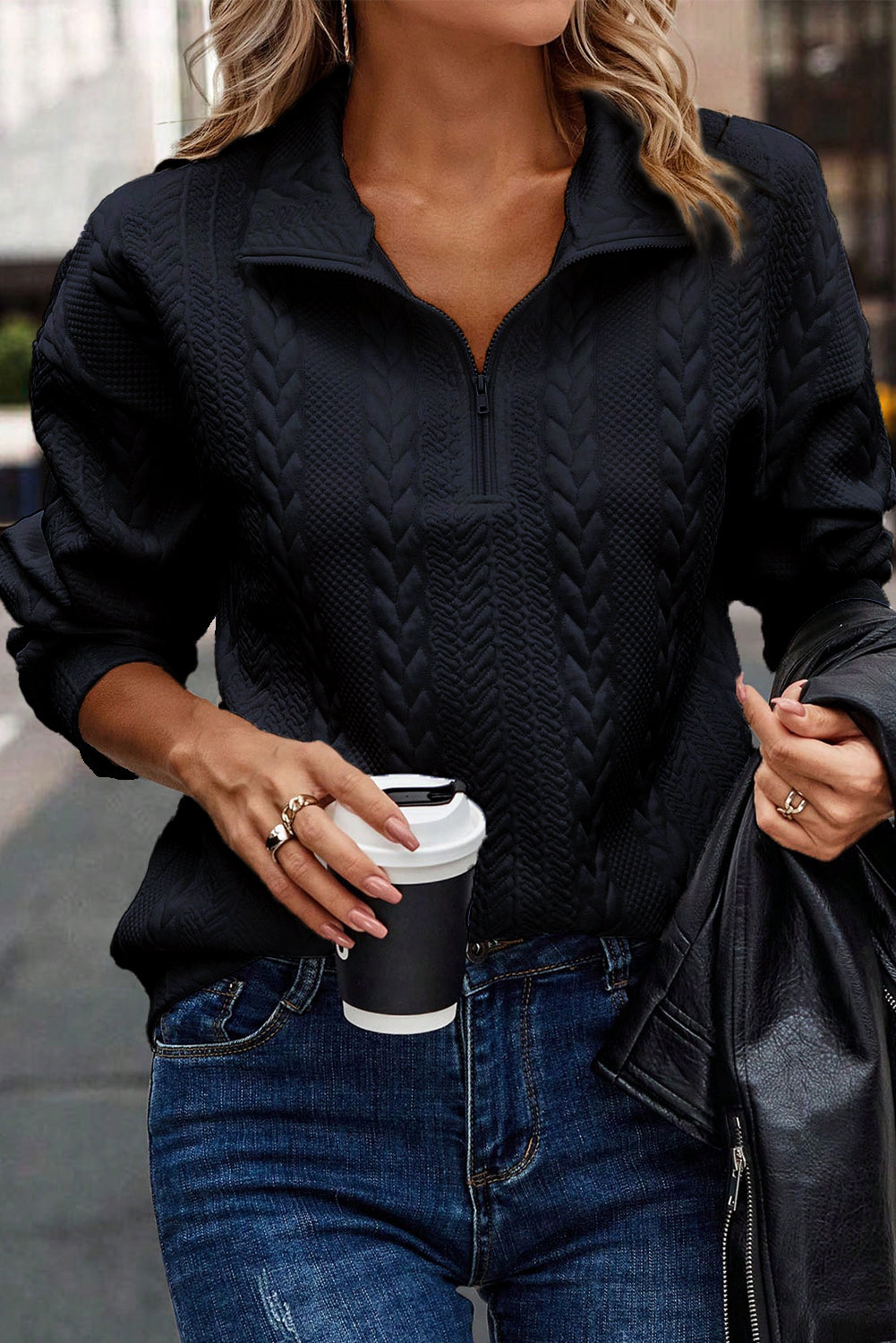 A person wearing a Navy Blue Zip Up Cable Textured Sweatshirt and blue jeans, seen from the back, standing on an urban street.