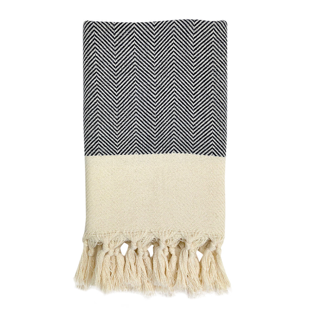 Product: The Herringbone Turkish Hand Towel is crafted from 100% Turkish cotton and displays a blue and white herringbone design, accented with a cream fringe border.
