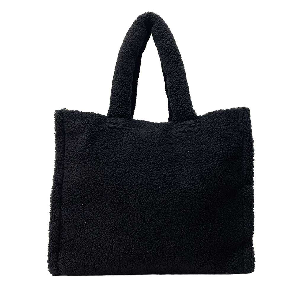 The Astrid Shopper Tote is a tote bag made from cozy blue teddy fleece. It showcases a straightforward rectangular shape with two sturdy handles and comes equipped with a zippered interior pocket for extra functionality.