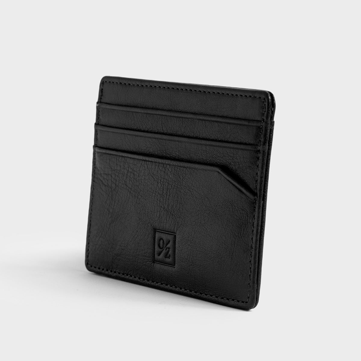 The Belforte - Slim Wallet is a stylish and lightweight black leather card-holder featuring an embossed logo, three card slots, and one easy-access side pocket. Displayed on a plain gray background, it combines elegance with functionality.