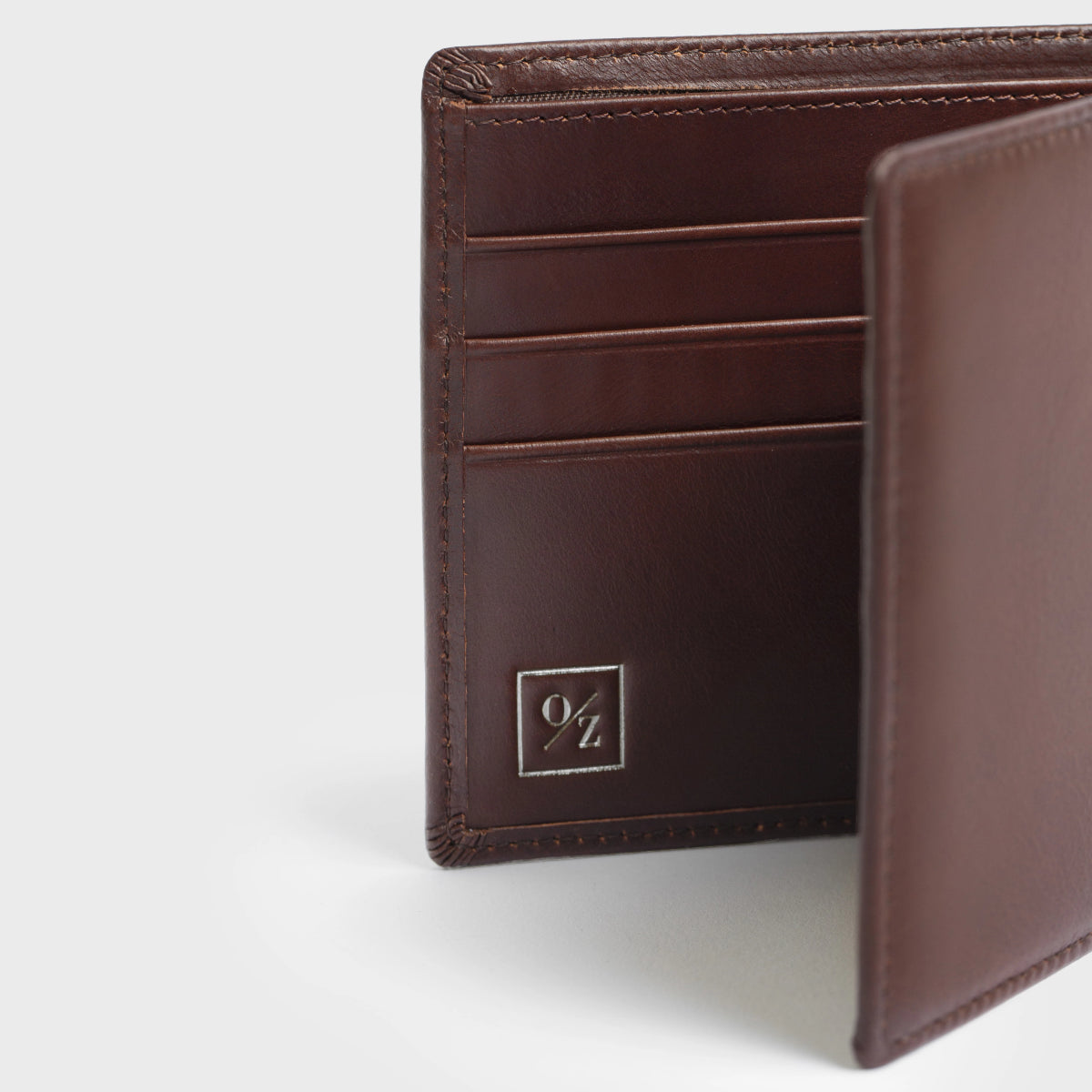 Close-up of the Lucca - Luxury Wallet, showcasing a contemporary design made from soft brown leather. It features a bi-fold layout with multiple card slots and is accented with a small, discreet gold logo in the corner.