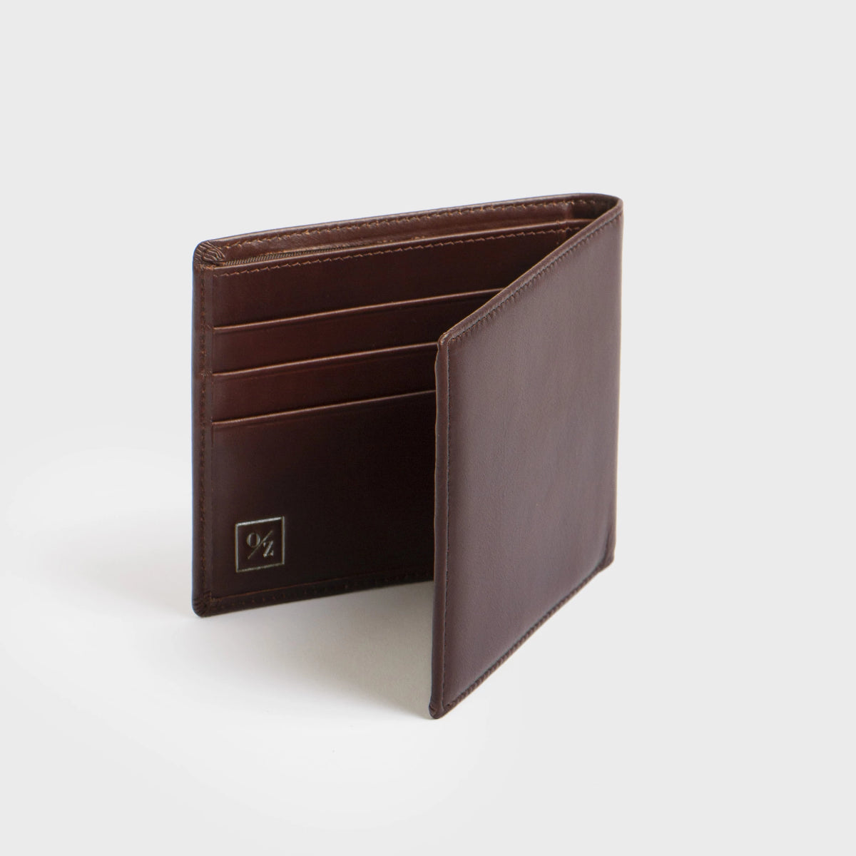 Close-up of the Lucca - Luxury Wallet, showcasing a contemporary design made from soft brown leather. It features a bi-fold layout with multiple card slots and is accented with a small, discreet gold logo in the corner.