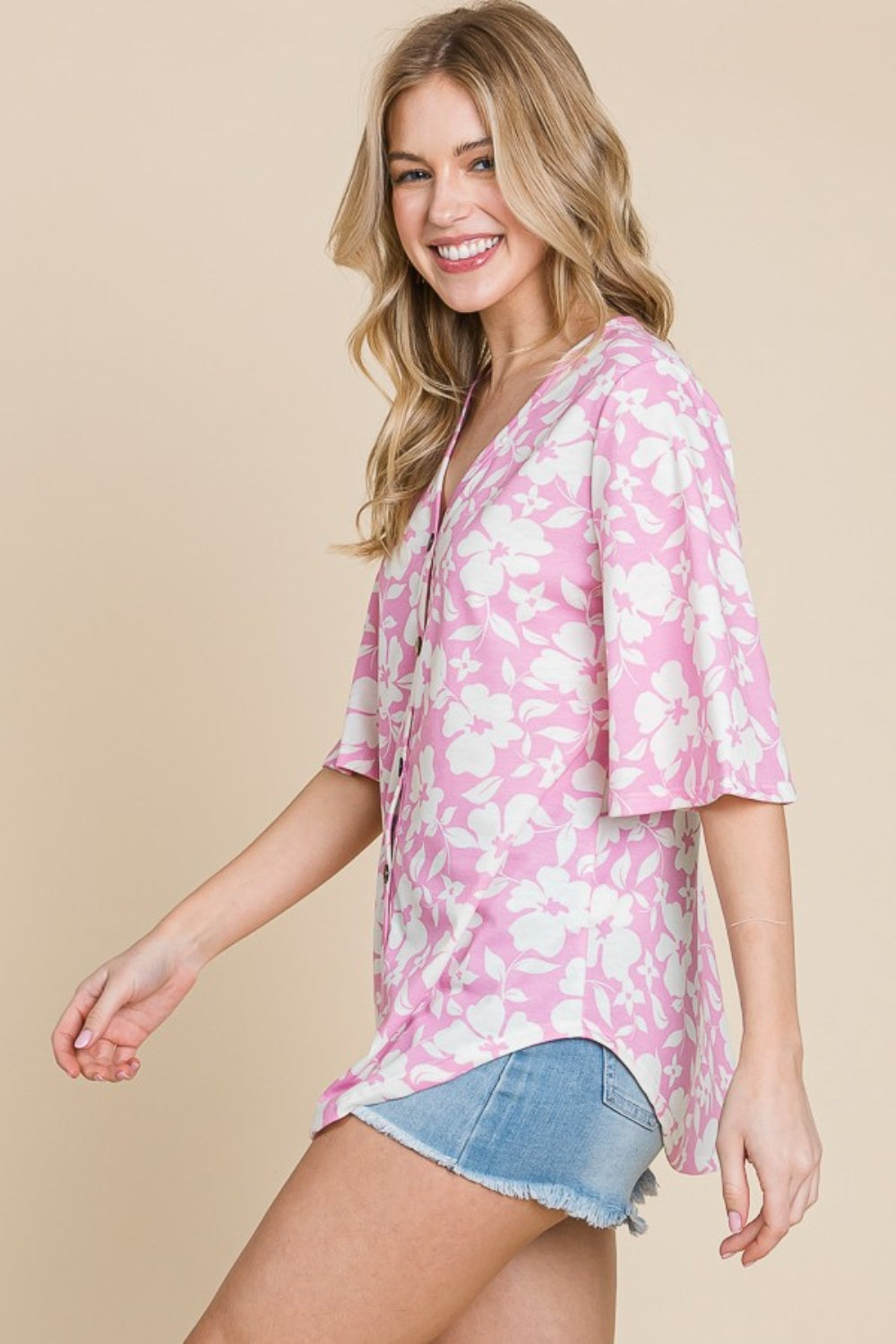 A woman wearing the BOMBOM Floral Decorative Button V-Neck Top in pink.