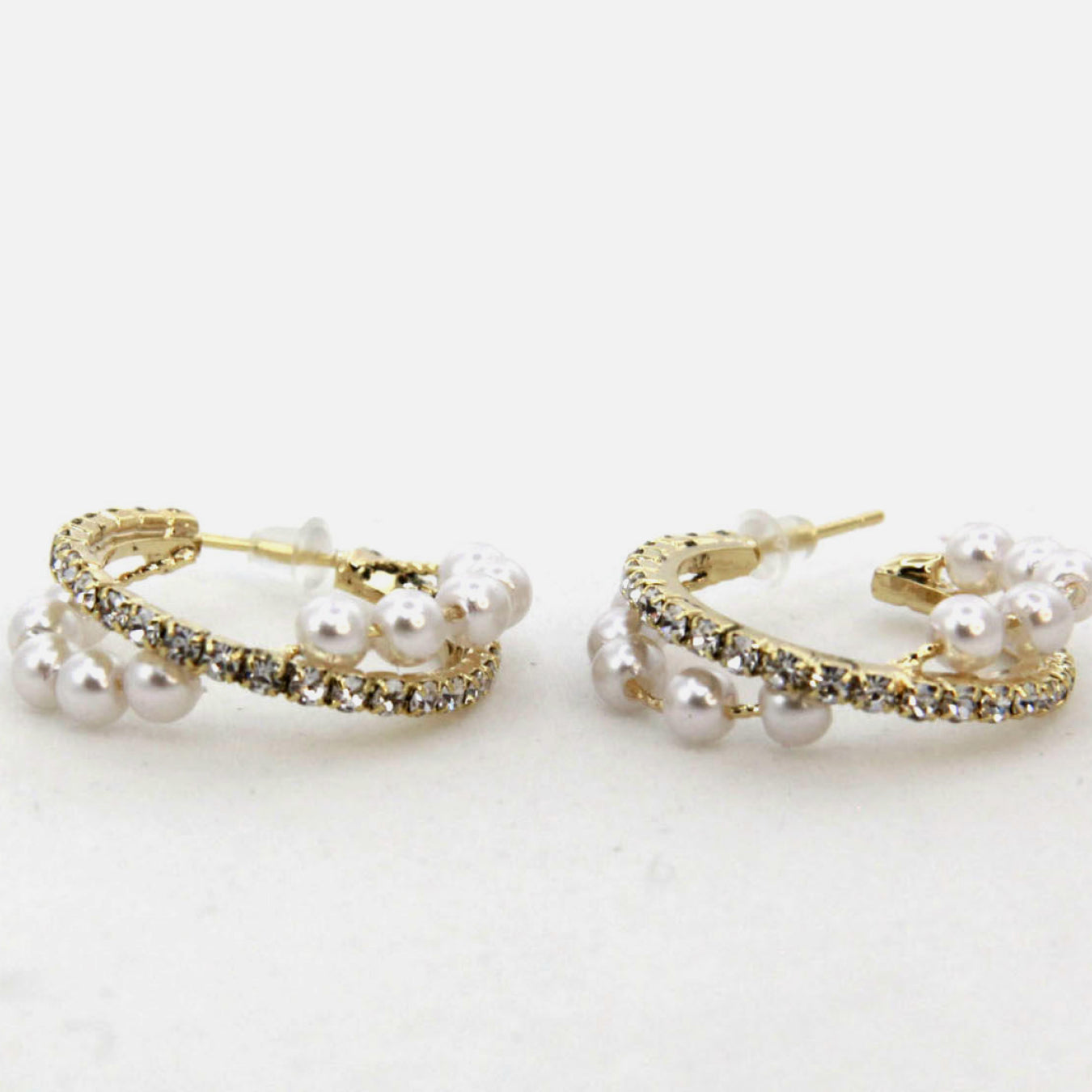 Alloy Pearl Hoop Earrings featuring gold hoops with imitation pearls and small clear gemstones, showcased on a vertical stand.