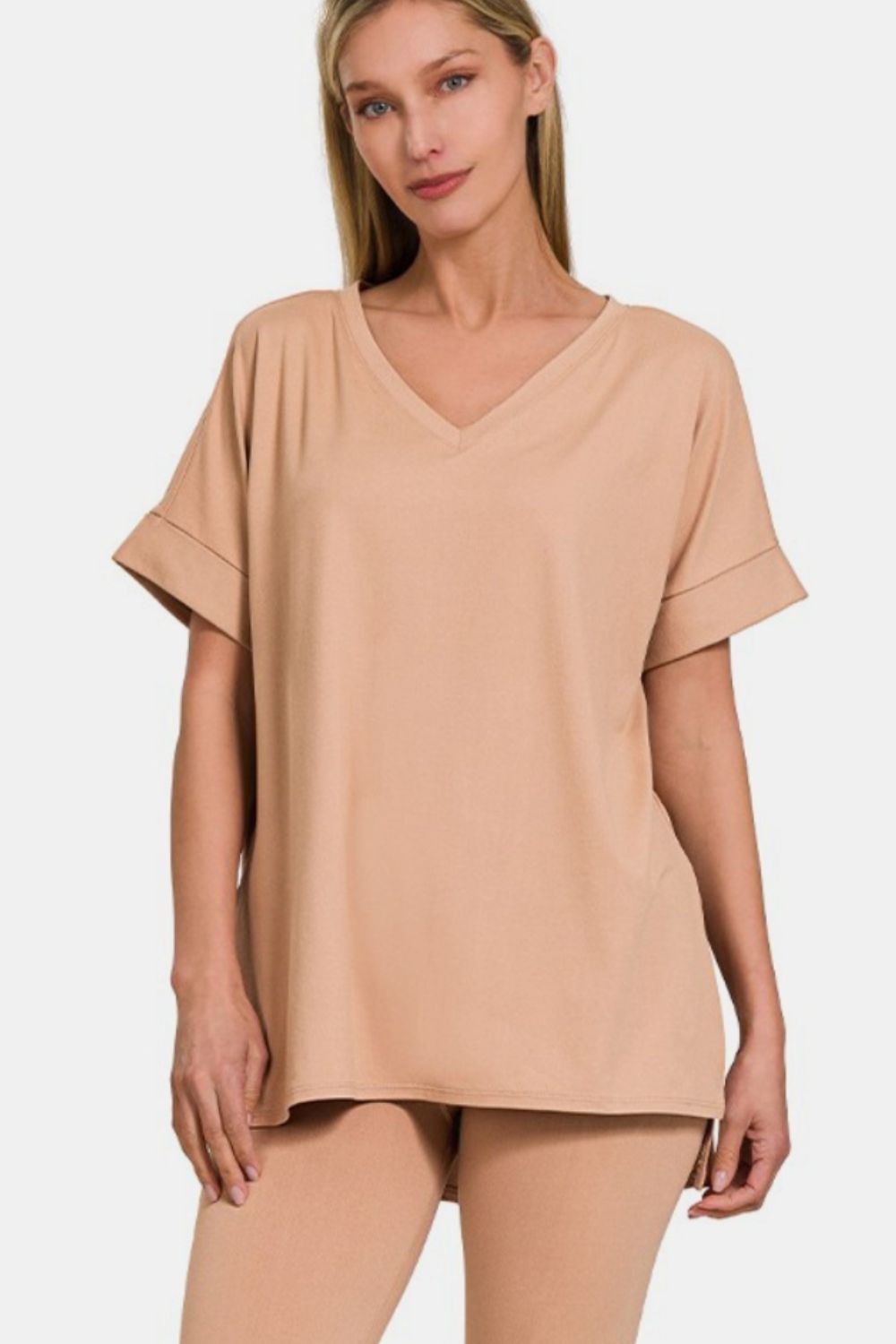 A person wearing the Zenana Full Size V-Neck Rolled Short Sleeve T-Shirt and Leggings Lounge Set in classic beige stands against a plain white background, exuding both comfort and style.