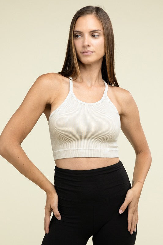 A person poses in a Washed Ribbed Seamless Cropped Cami Top with removable bra pads and black leggings against a neutral background.