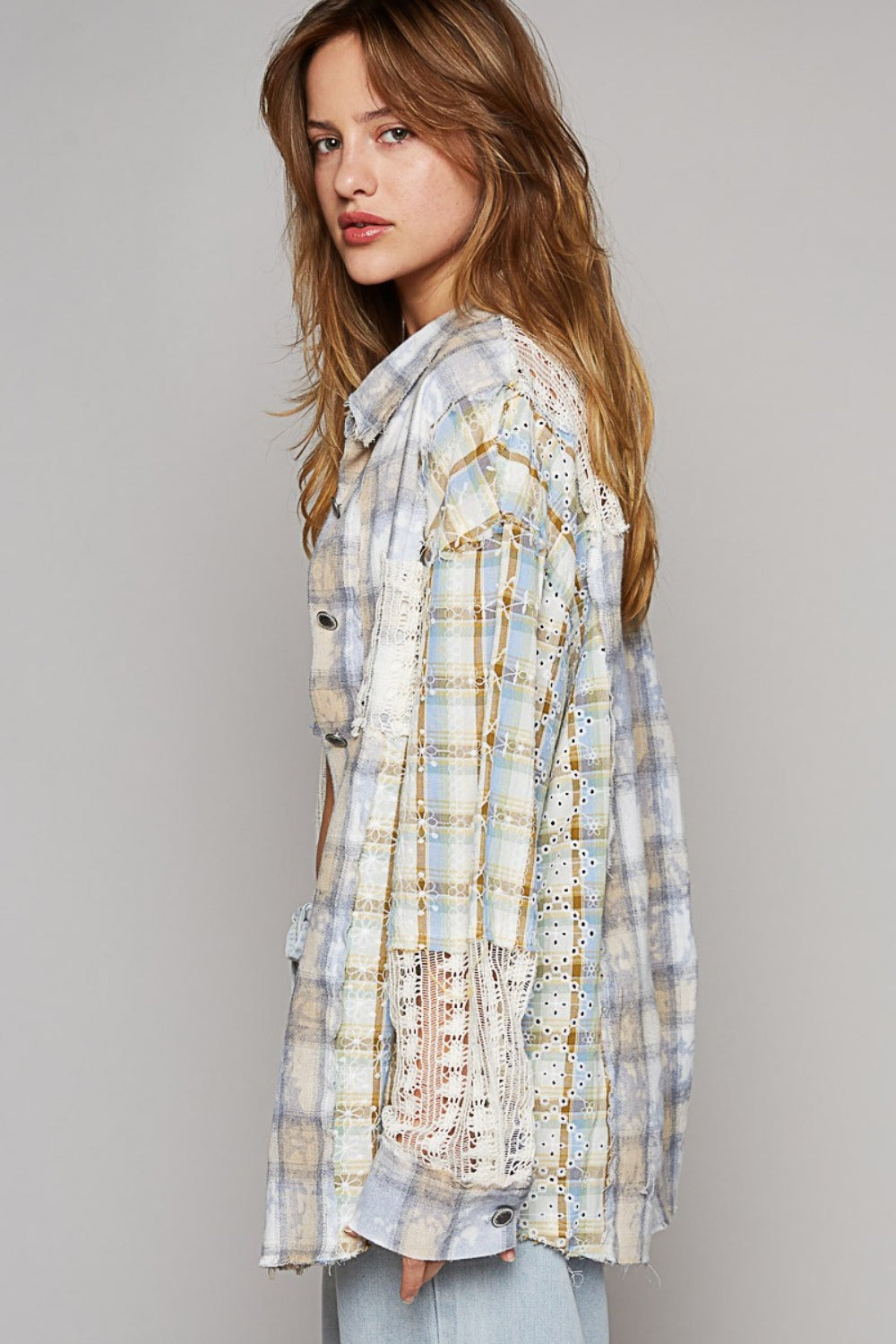 A young woman poses against a plain background, wearing the POL Long Sleeve Embroidered Crochet Plaid Shirt over a white crop top and drawstring light-blue pants.