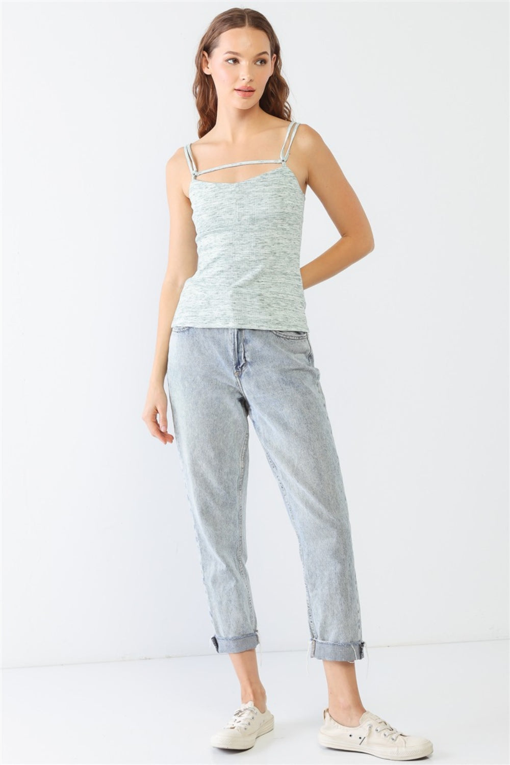 Dressed in a stylish Le Lis Heathered Ribbed Adjustable Strap Cami, a person stands against a plain background, paired with jeans.