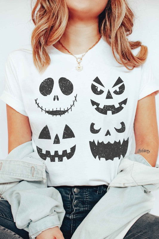 A person wears the SCARY PUMPKINS Graphic Tee, featuring four black, scary pumpkin faces, paired with checkered shorts.