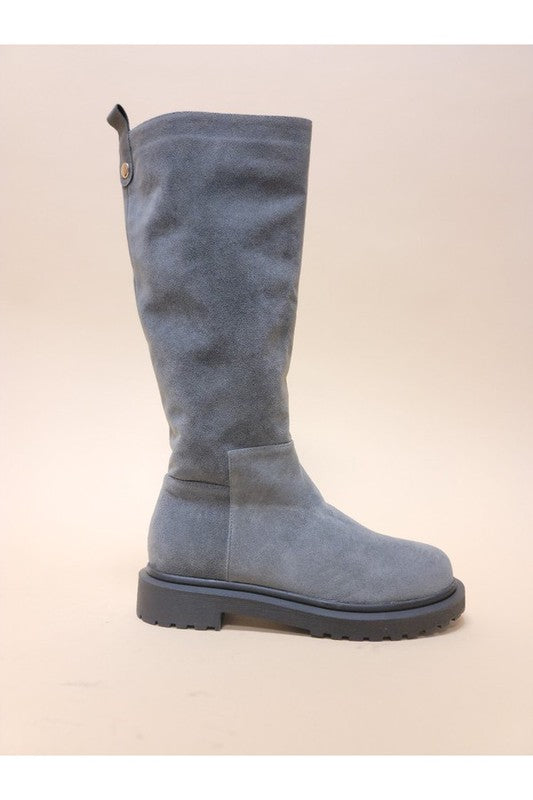 Three pairs of UNA-LONG BOOTS in beige, grey, and black are aligned in a row against a neutral background. These casual suede long boots feature chunky rubber soles and block heels.