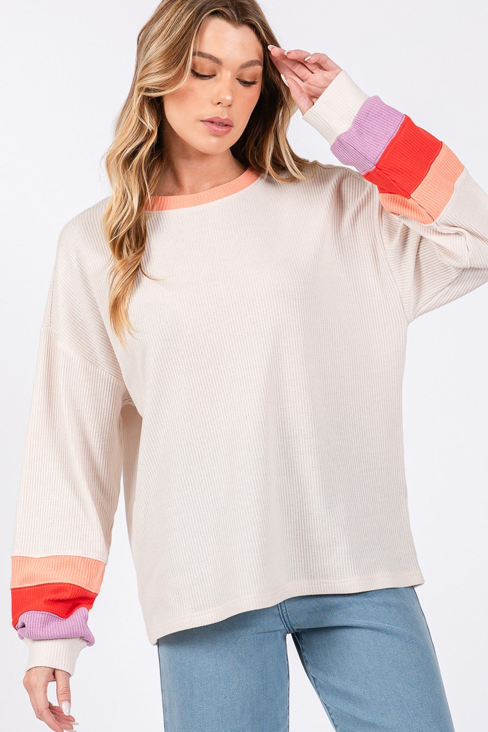 A person wearing the SAGE + FIG Color Block Waffle Knit T-Shirt, blue jeans, and a black cap stands against a plain background.