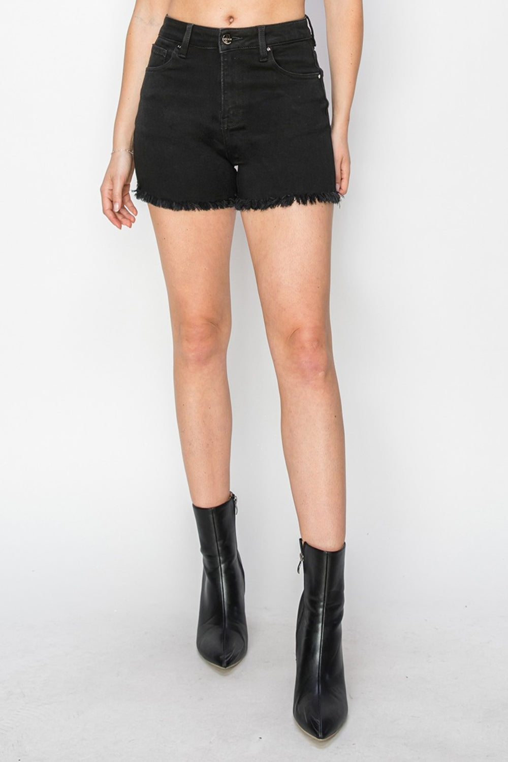 A person wearing RISEN Full Size High Waist Raw Hem Denim Shorts stands against a light background, perfect for a summer wardrobe.