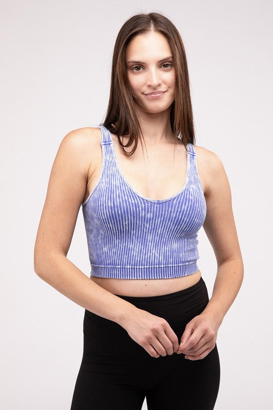 A woman in a Washed Ribbed Cropped V-Neck Tank Top and jeans posing with her hand on her head against a plain background.