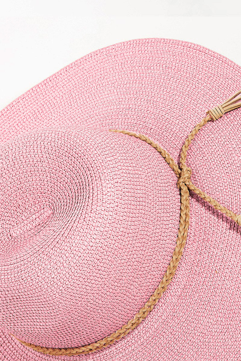 The Fame Straw Braided Rope Strap Fedora Hat exudes bohemian charm with its wide-brimmed design, pink straw material, braided rope trim, and tassel details, all beautifully displayed on a neutral background.