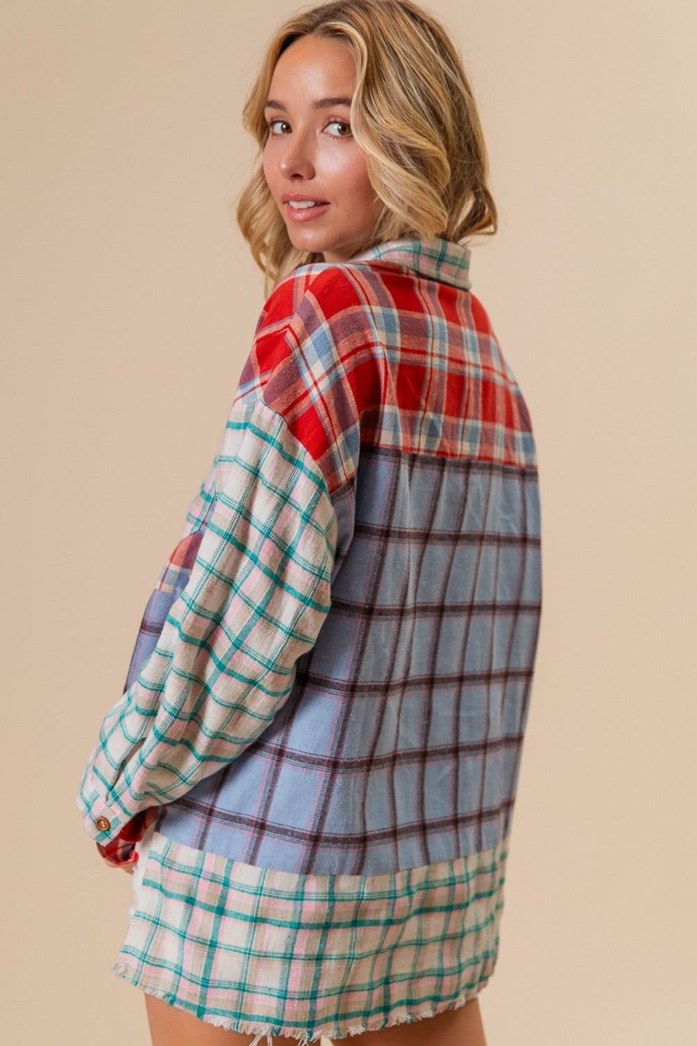 A person wearing a vibrant BiBi Color Block Plaid Button Down Shirt and white denim shorts stands against a neutral background.