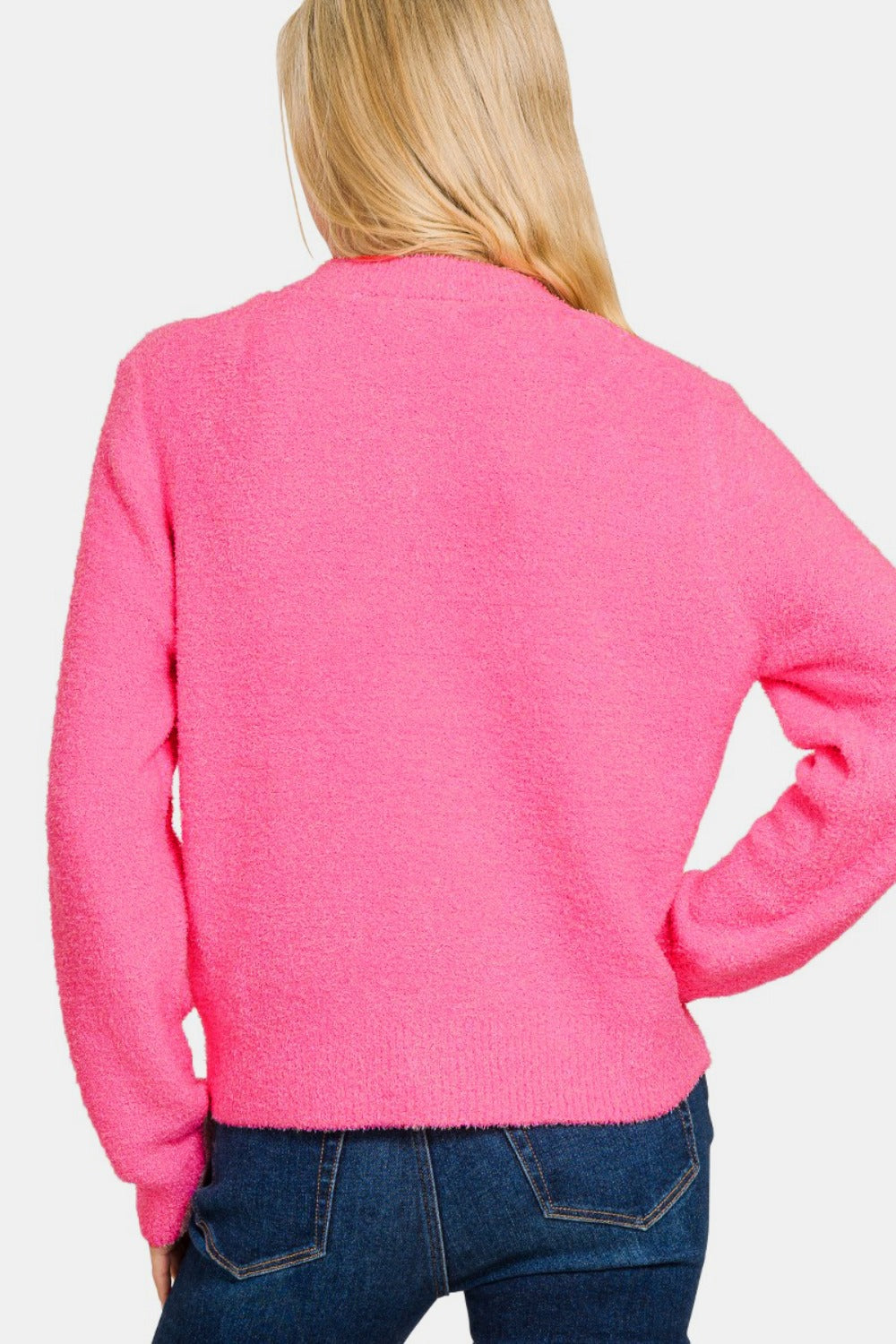 A person with long blonde hair wears a Zenana Button Down Long Sleeve Sweater Cardigan in bright pink and dark blue jeans, posing against a plain white background.