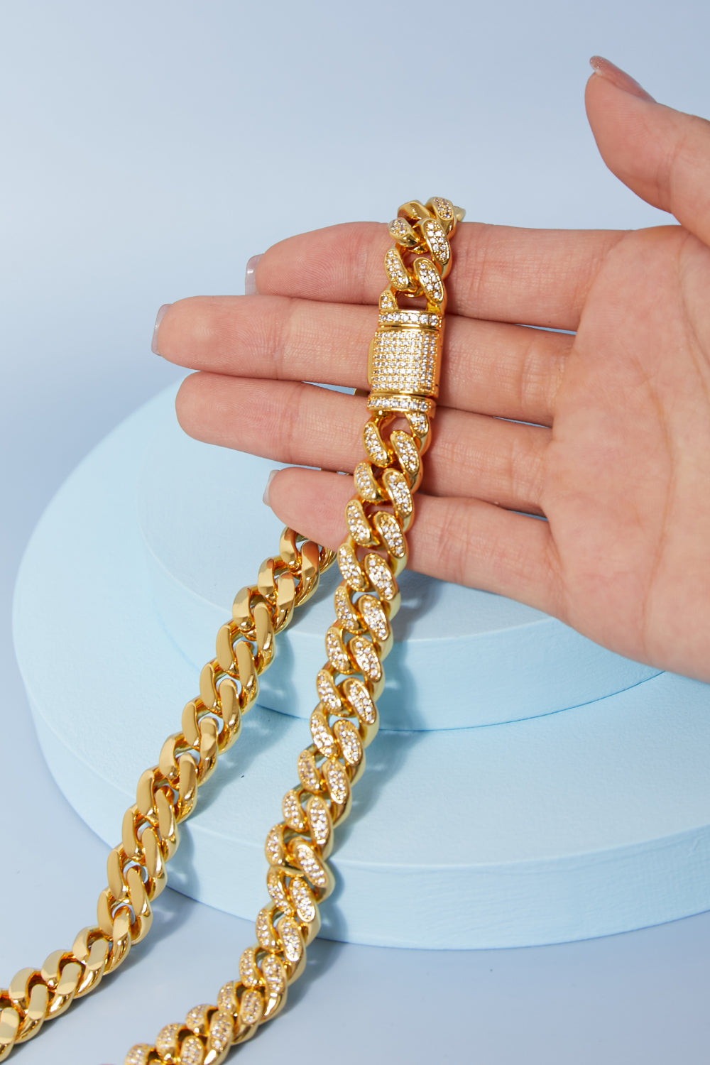 Brass Curb Chain Necklace elegantly displayed on a light blue round surface.