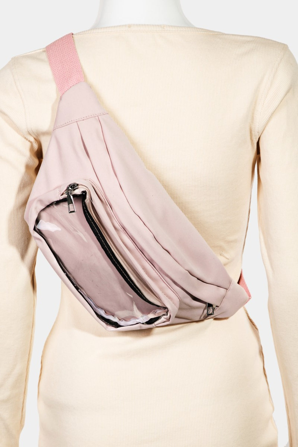 A woman wearing a black sleeveless top and beige pants showcases the Fame Adjustable Strap Sling Bag, styled as a pink crossbody fanny pack, against a light background. Her long, wavy blonde hair complements the look of this versatile accessory, ideal for everyday use.