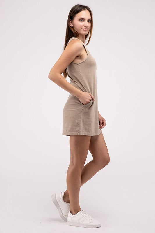 A woman stands in a casual pose, wearing a sleeveless, rust-colored Sleeveless Mini Dress with side pockets in front of a plain light background.